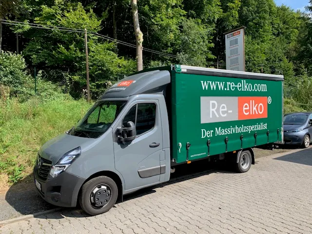 Lieferwagen von Re-elko mit grüner Plane vor dem Betriebsgelände in Hofheim