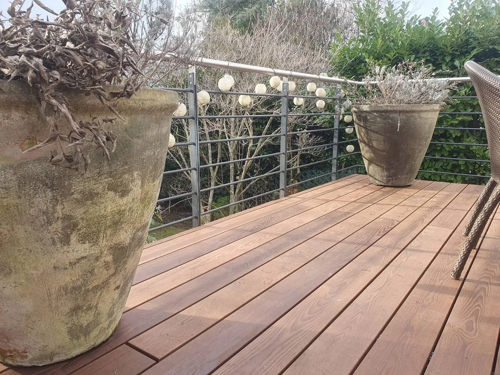 Terrasse aus Thermo-Esche mit Pflanzkübeln und Blick in den Garten